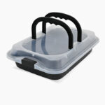 Tepsija za torte s poklopcem koji je providan i podignutim crnim ručkama uslikana iskosa.